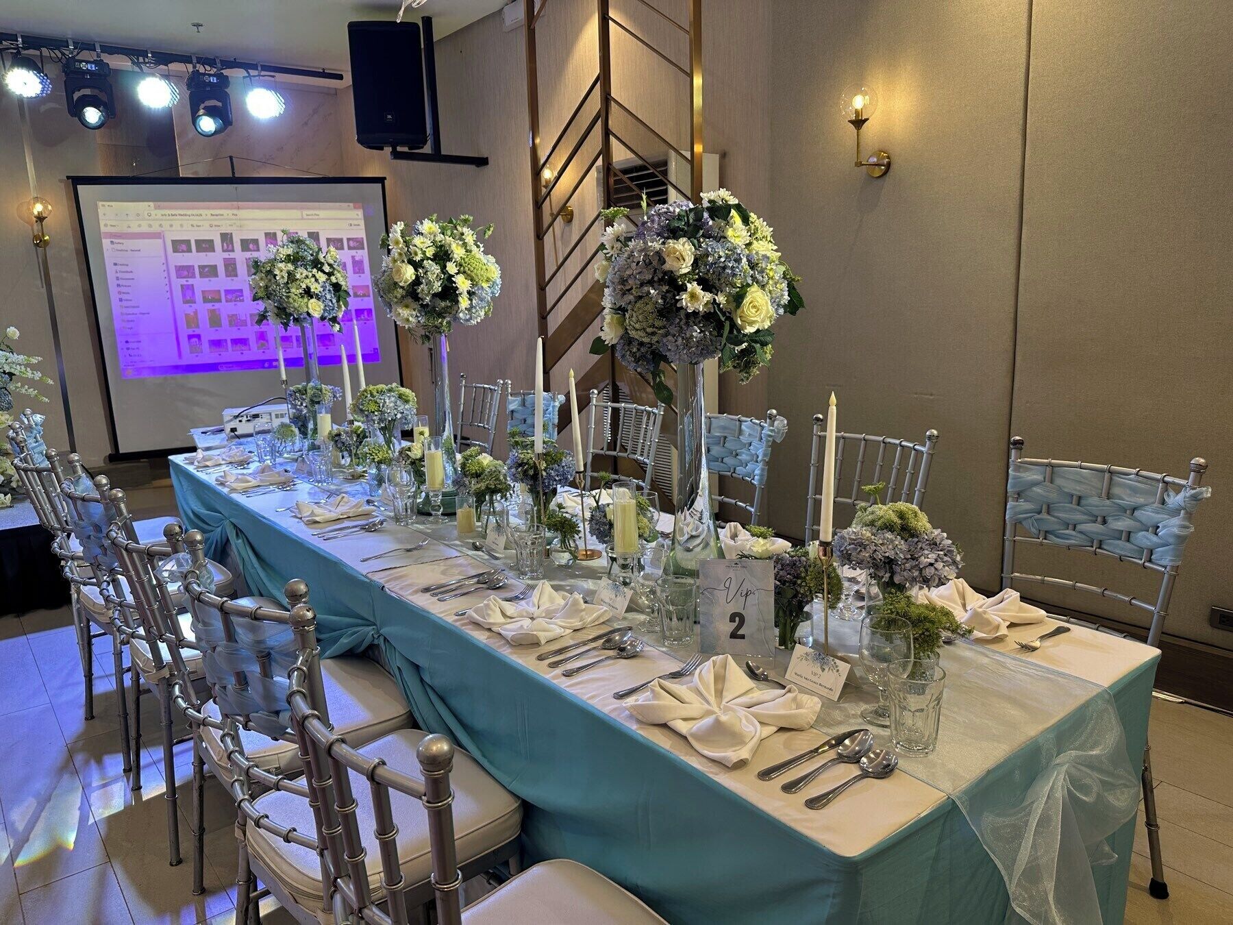 A banquet table set with chairs, floral centerpieces, and numbered place cards.