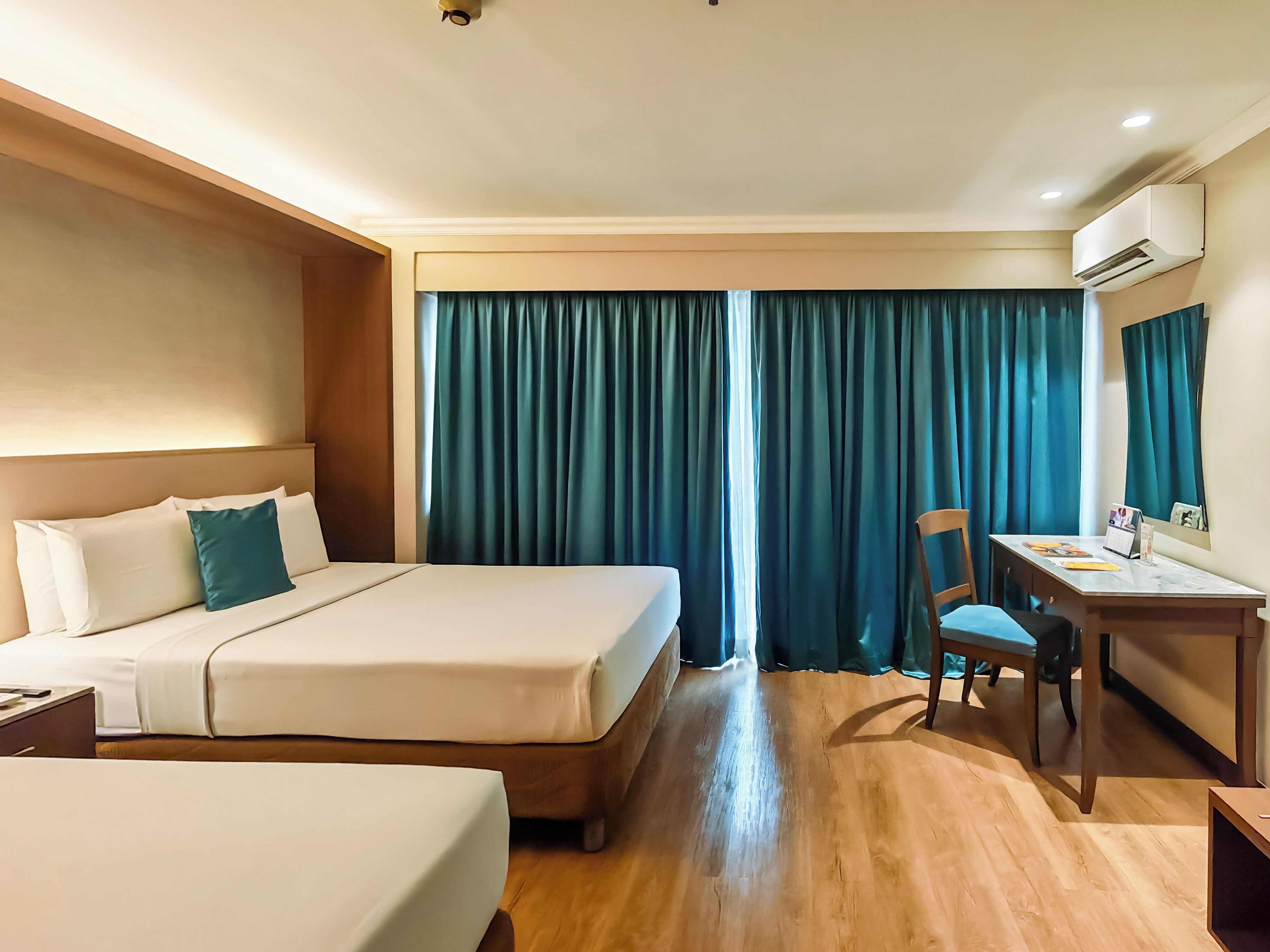 A hotel room with a bed, a desk, and a chair.