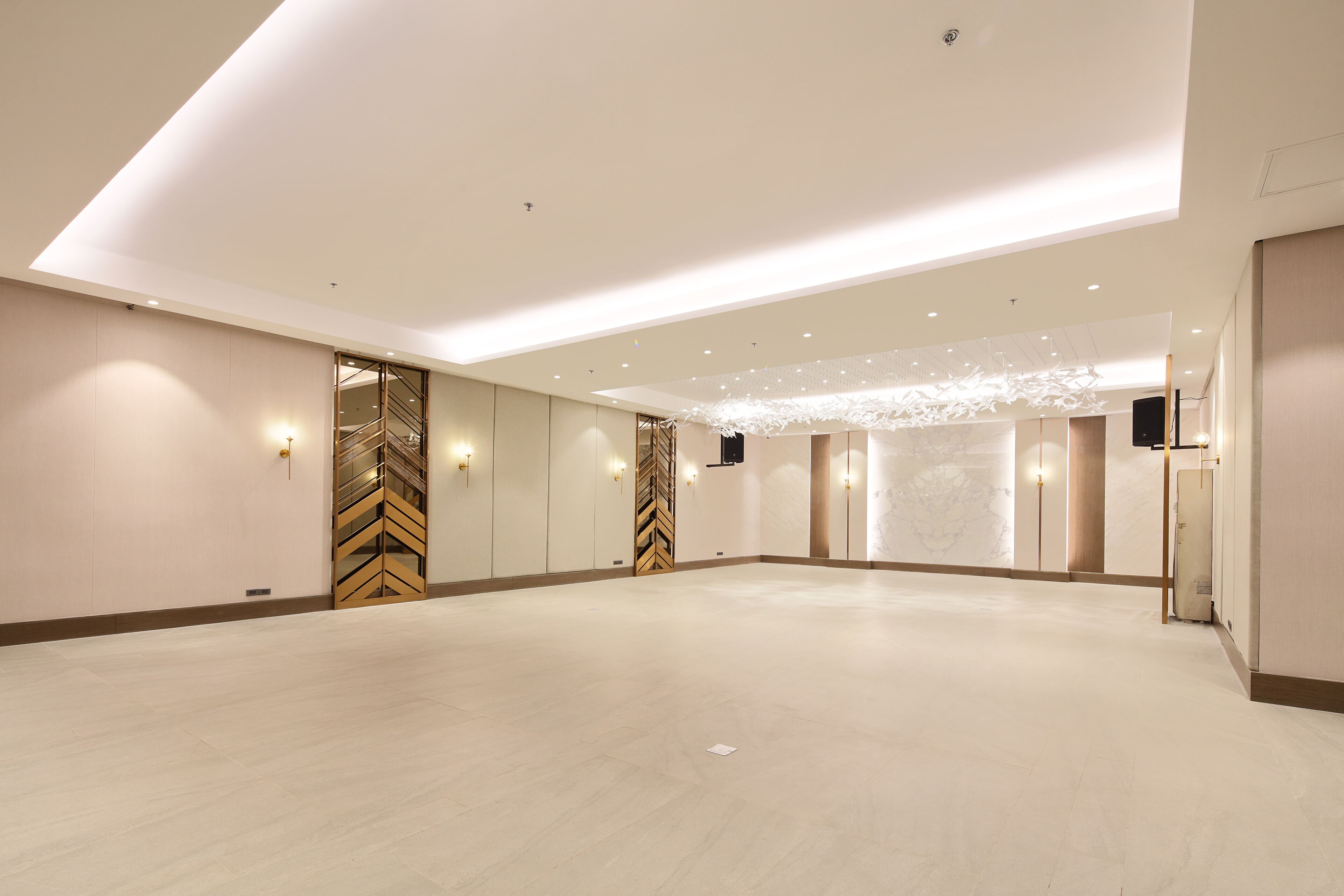 A spacious, well-lit conference room with a high ceiling, recessed lighting, and a modern design.