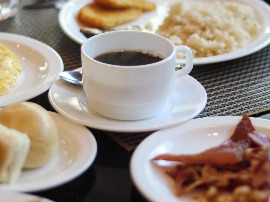 A table with various breakfast items including eggs, bacon, and coffee.