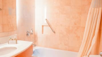 A bathroom with a bathtub, toilet, and sink.