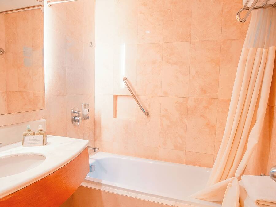A bathroom with a bathtub, toilet, and sink.