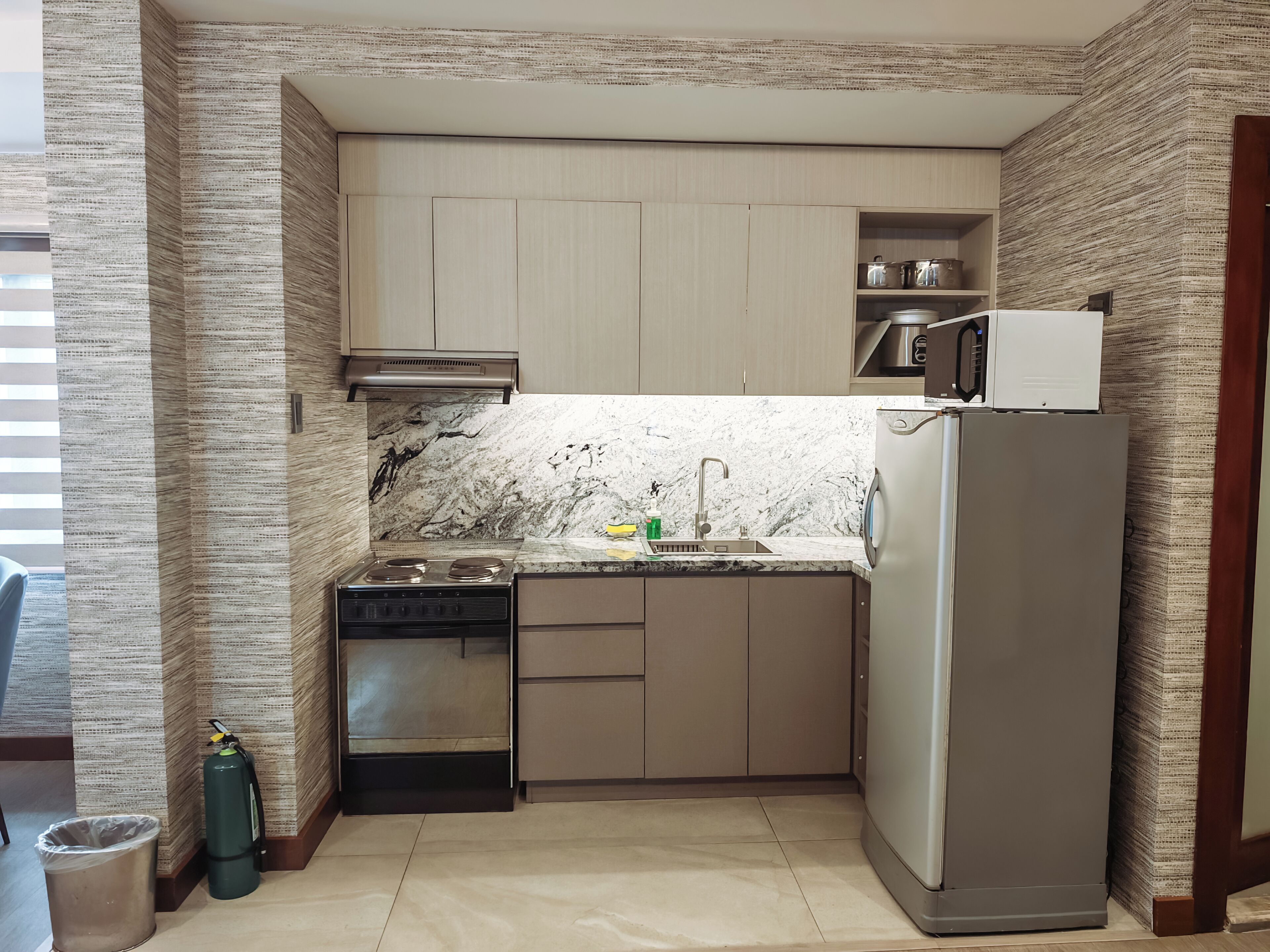 A compact kitchen with a built-in stove, a sink, and a refrigerator.