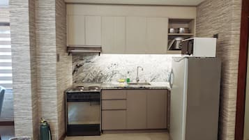 Una cocina compacta con estufa integrada, un lavamanos y un refrigerador.