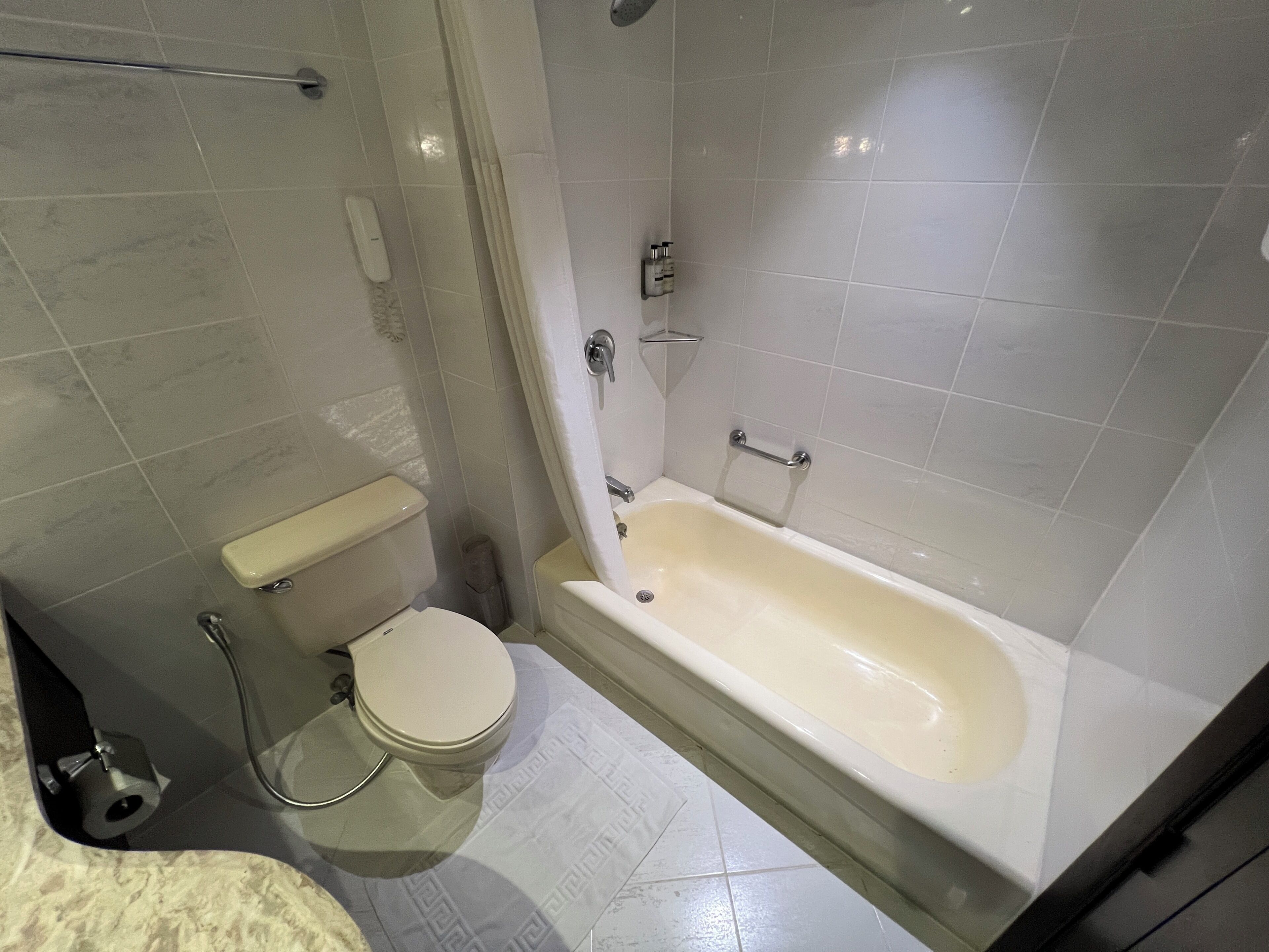 Un baño con inodoro, bañera y zona de ducha.