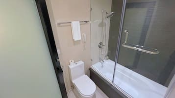 A modern bathroom with a toilet, a glass-enclosed shower, and a white sink.