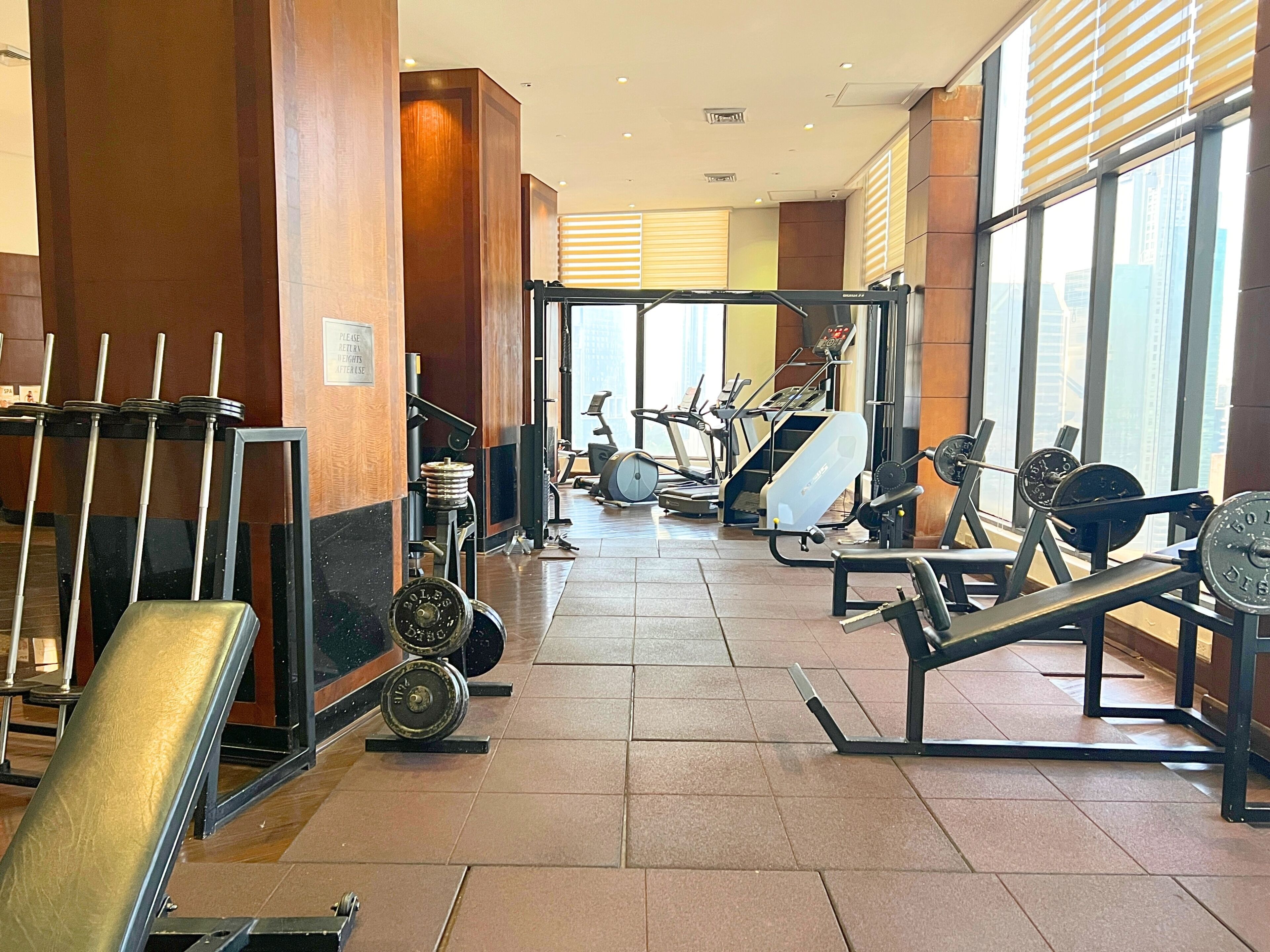 A gym with exercise equipment, a weight bench, and a treadmill.