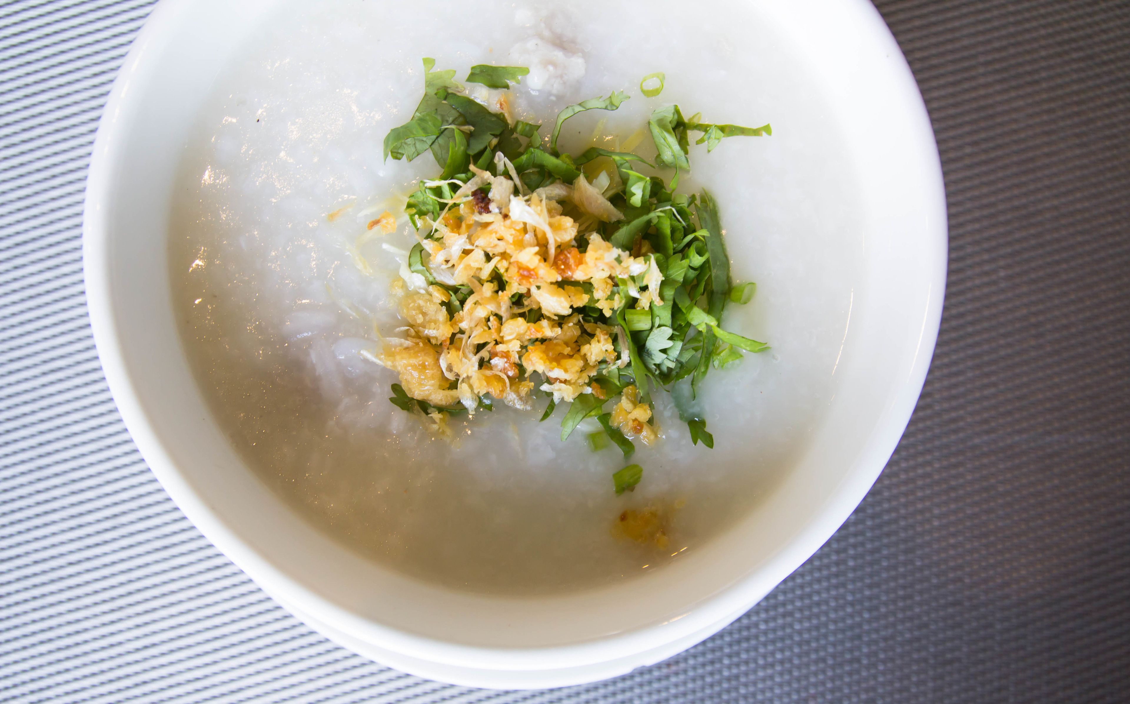 A bowl of clear soup with garnishes.