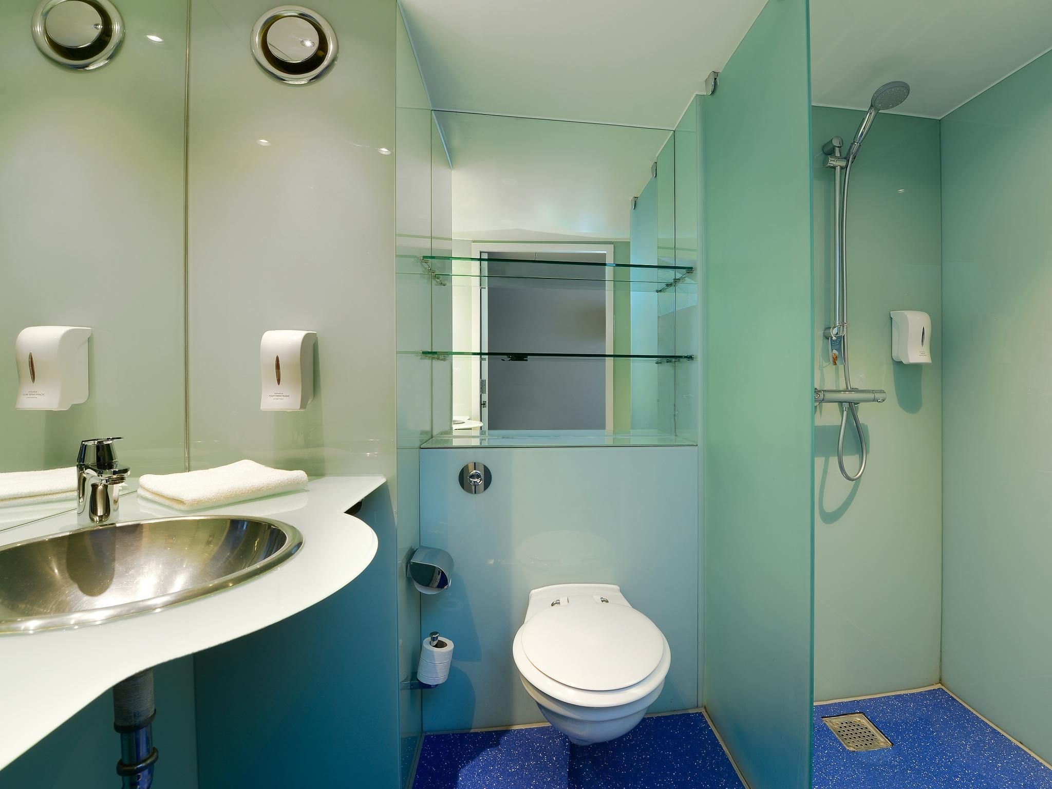 A modern bathroom with a sink, toilet, and shower.