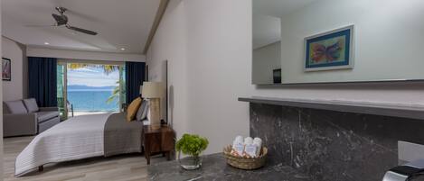 Een moderne slaapkamer met een bed, een nachtkastje, een lamp, een kleine plant en een badkamermeubel met toiletartikelen.