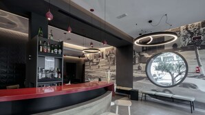 A modern bar area with a curved counter, bar stools, and pendant lighting. - Best Western Hotel Corsi (Fiumicino)
