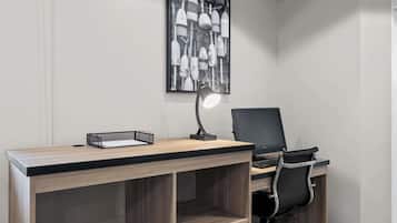 A modern office desk with a computer, a chair, and a desk lamp.