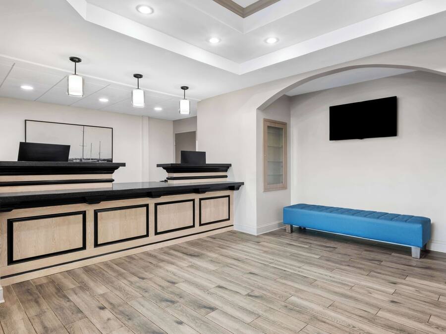 A modern kitchen with a wooden countertop, recessed lighting, and a blue bench.