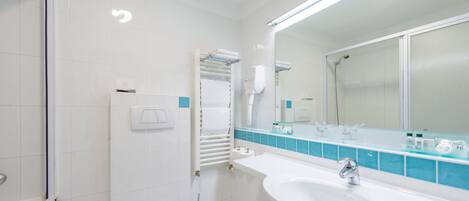 Een moderne badkamer met een witte wastafel, een spiegel en een douche.