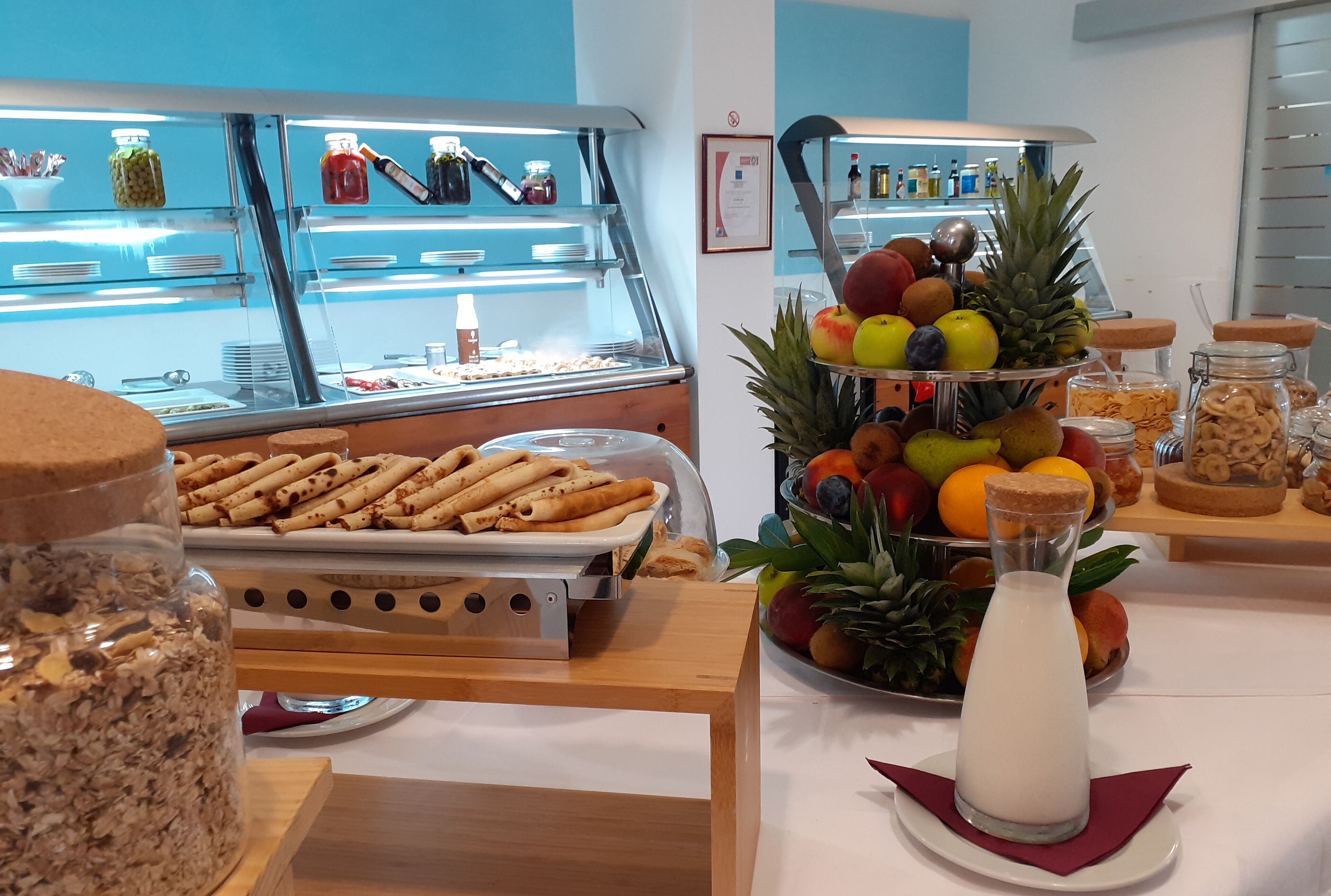 Um buffet de café da manhã com diversos alimentos e uma variedade de frutas.