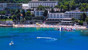 A coastal town with a beach, boats, and buildings. - Hotel Uvala (Dubrovnik)