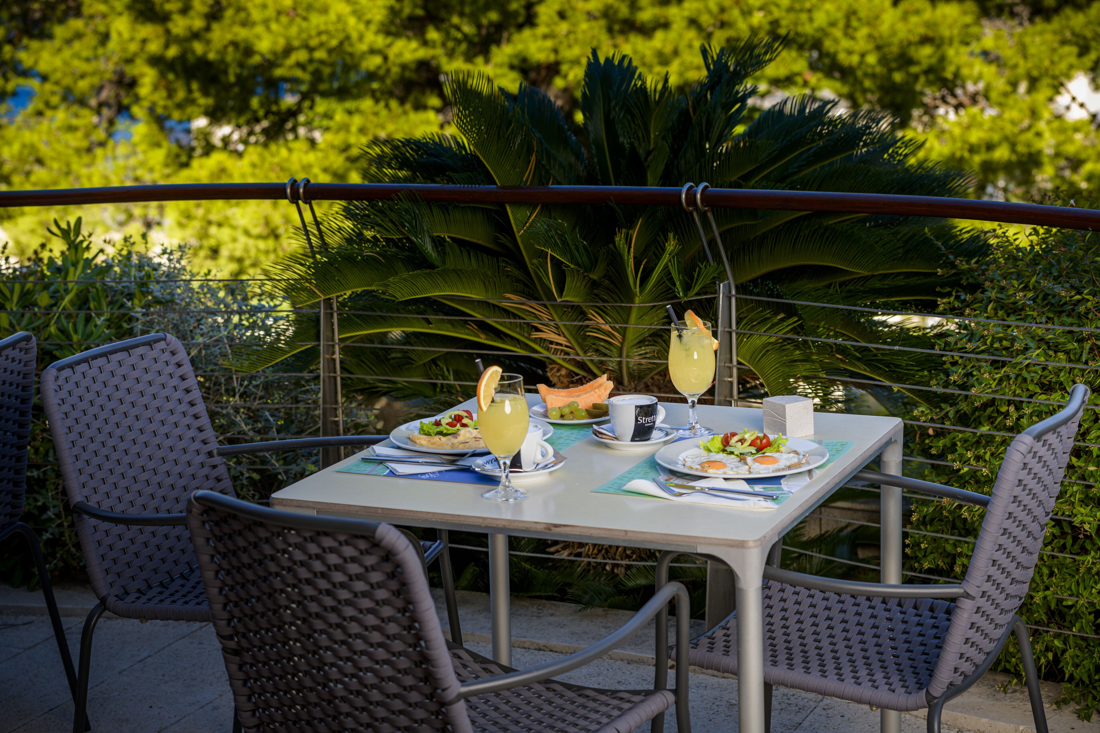 A table set outdoors with a view of lush greenery.