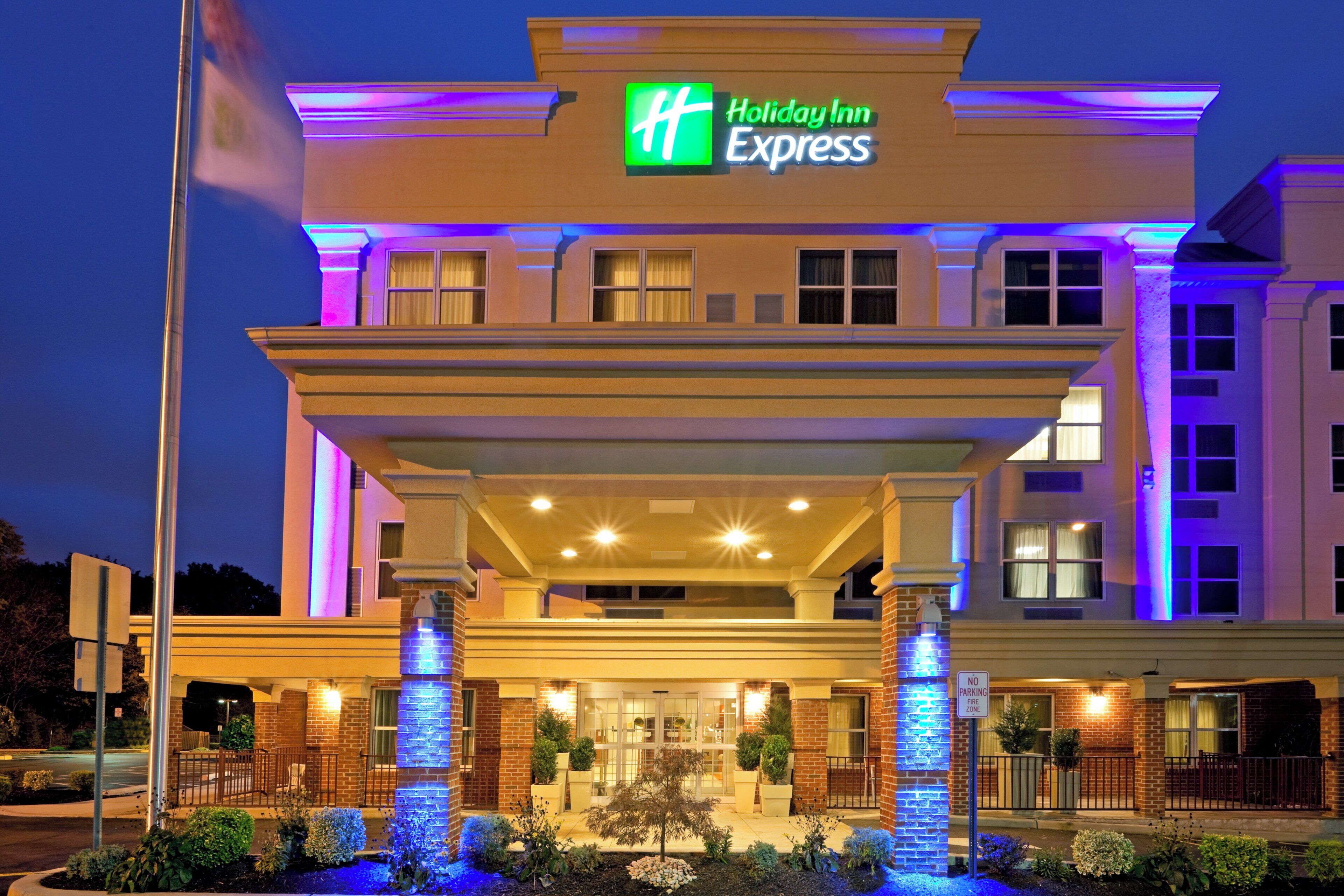 Een Holiday Inn Express hotel met een overdekte ingang, een gevel van baksteen en verlichte borden.