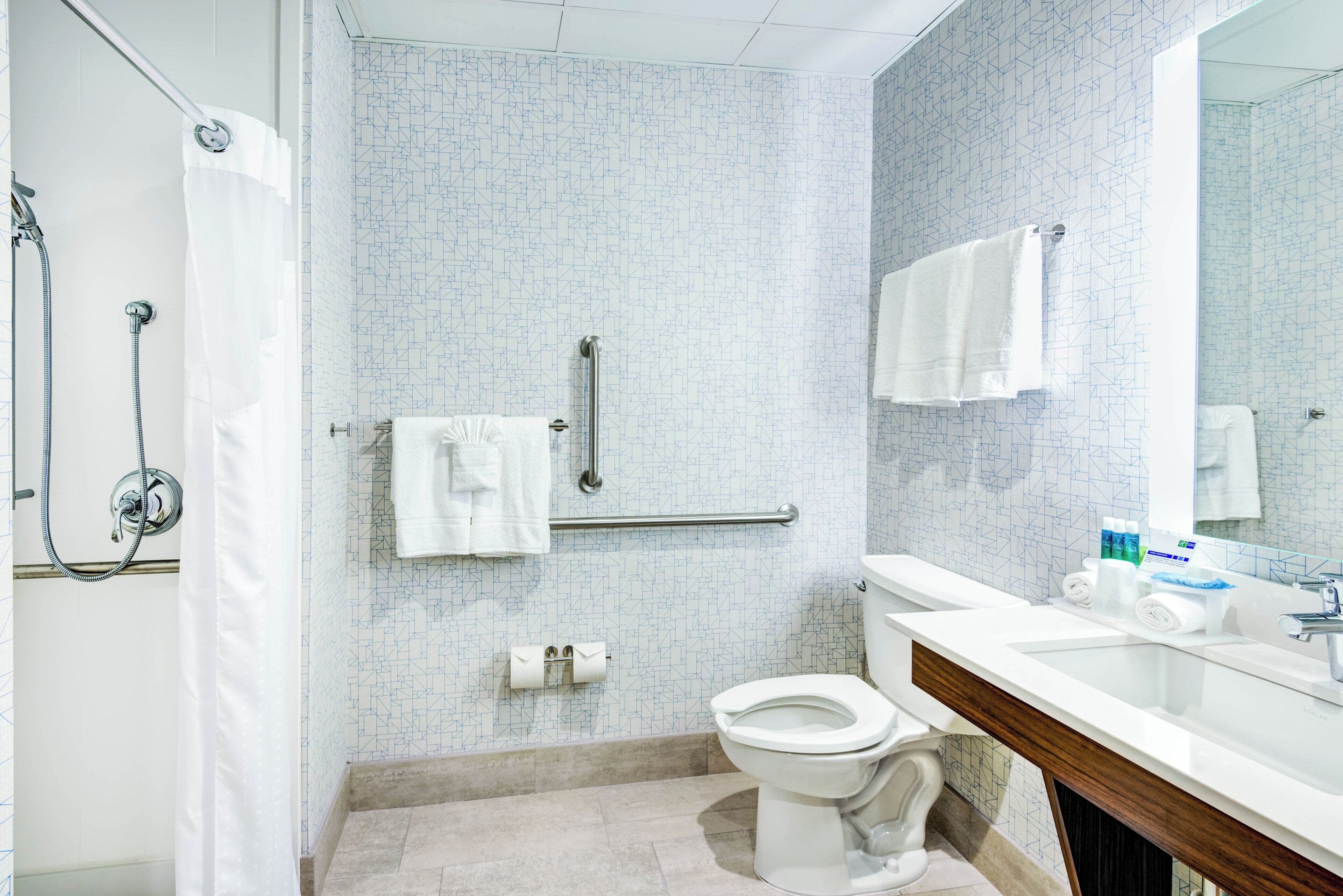A modern bathroom with a shower, toilet, and sink.