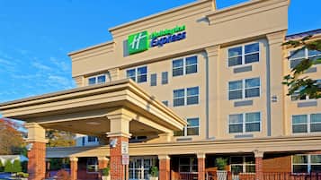 A Holiday Inn Express building with a covered entrance, multiple windows, and a brick facade.