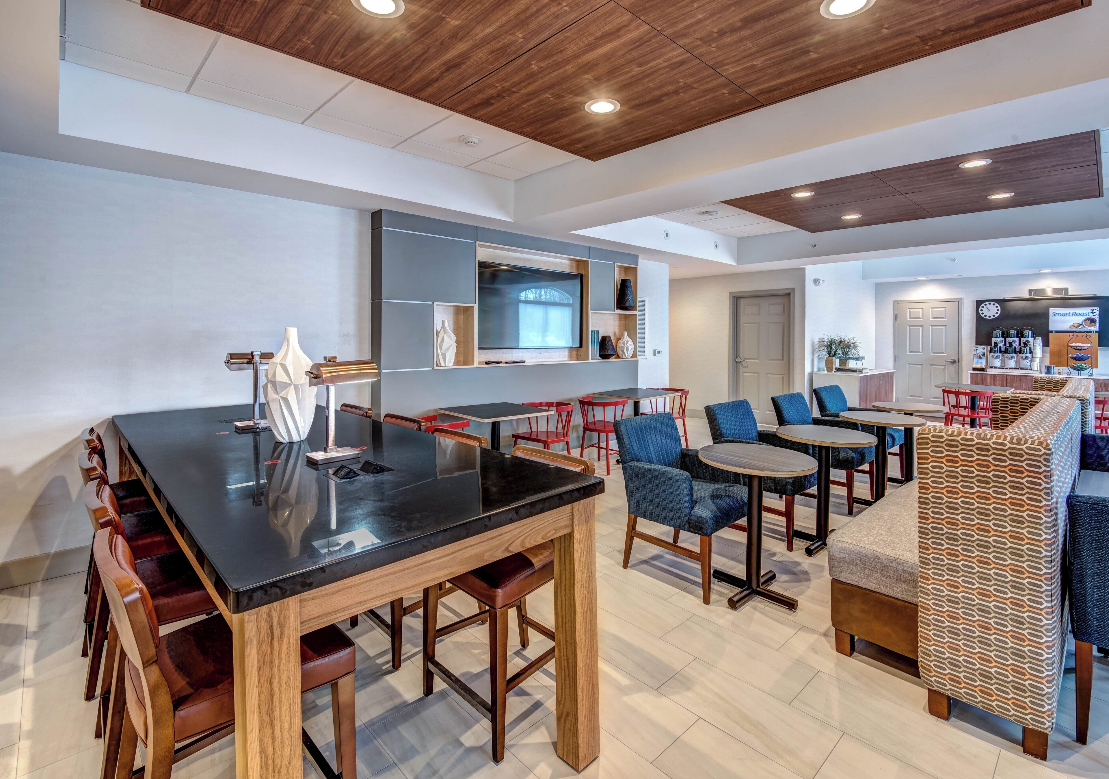 A modern interior with a bar area, seating, and a kitchen in the background.