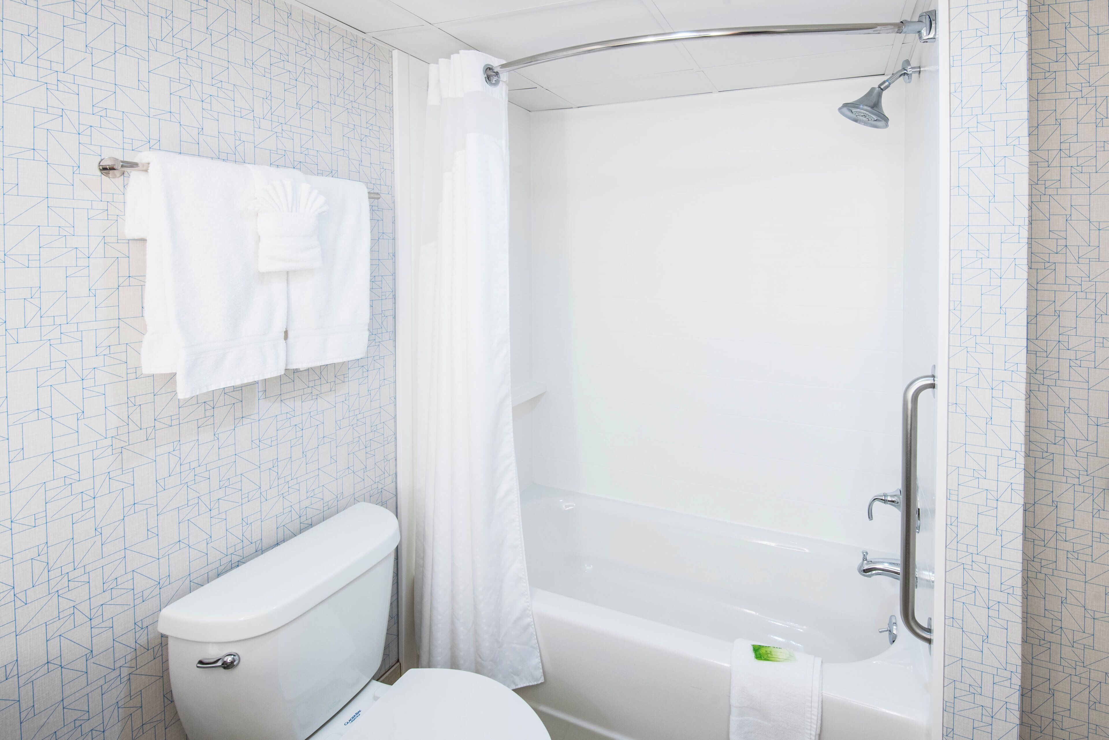 A bathroom with a toilet, a shower with a glass door, and a bathtub.