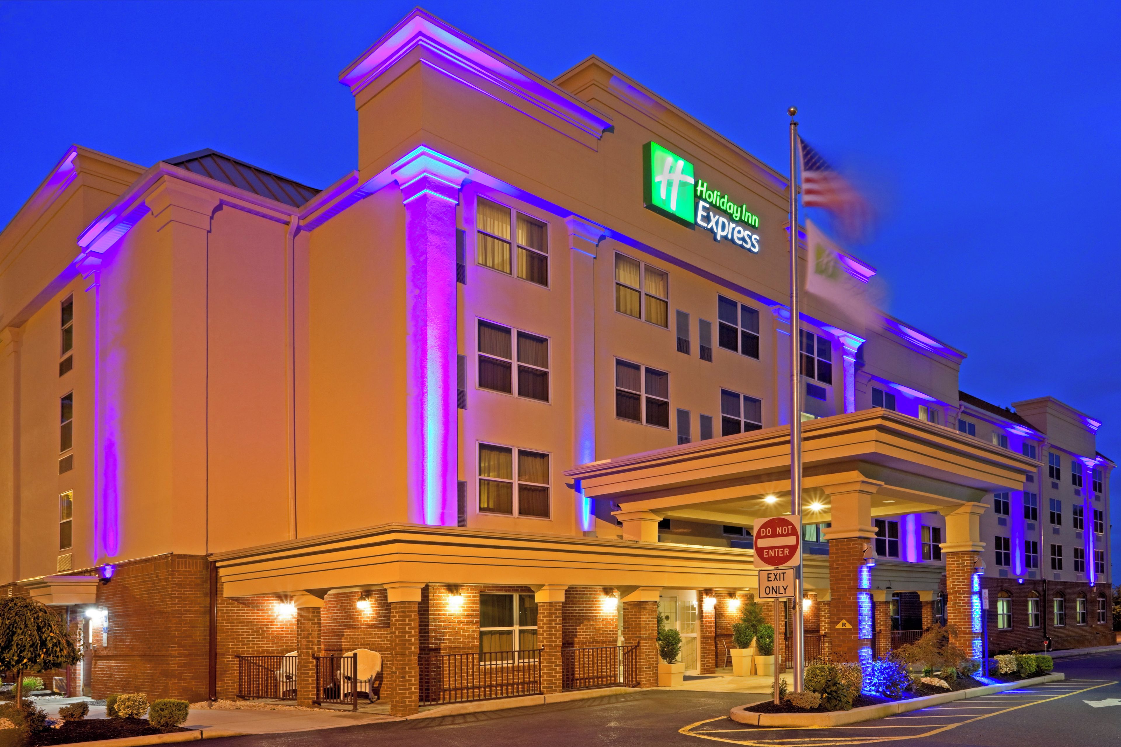 Edificio de Holiday Inn Express con una entrada destacada, un cartel de 'No Entrar' y otro cartel en la calle.