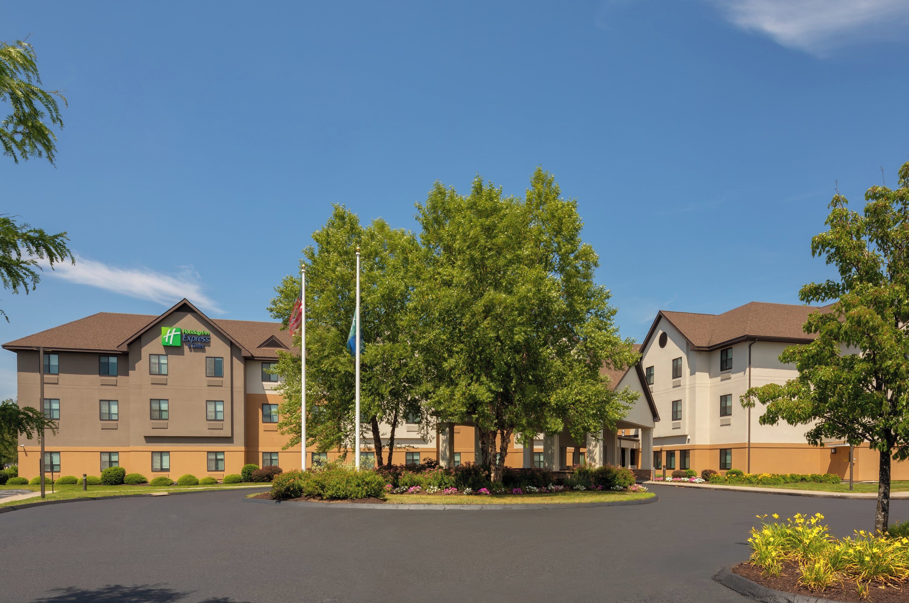 Un hotel Holiday Inn Express con estacionamiento y zonas verdes circundantes.