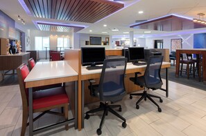 Een moderne kantoorruimte met meerdere werkplekken, elk voorzien van een computer en ergonomische stoelen.