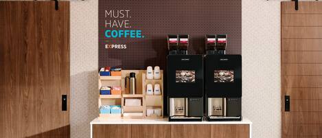 Una estación de café con dos máquinas de espresso, un molinillo y diversos artículos relacionados con el café.