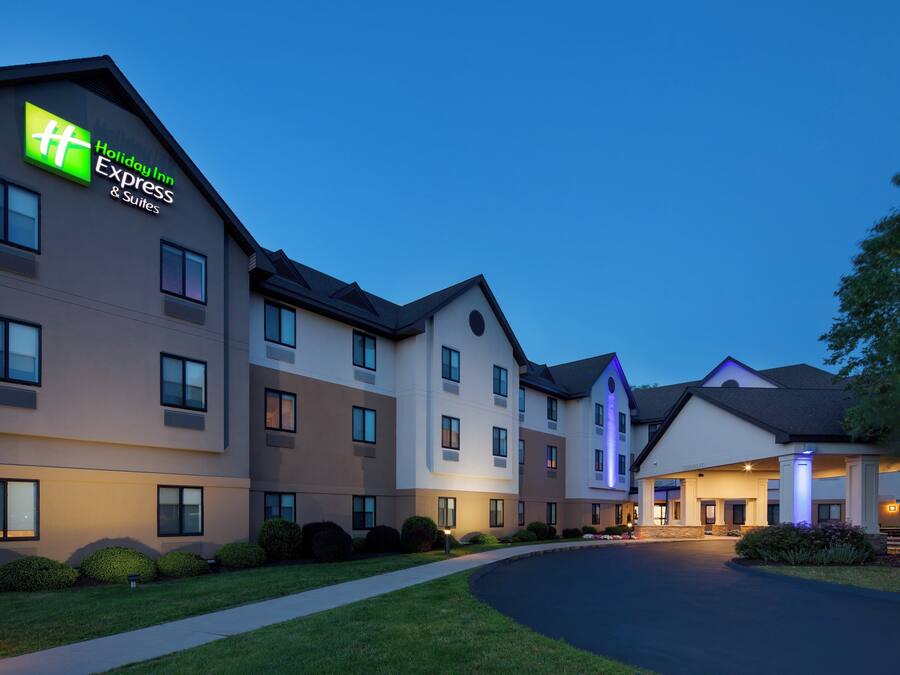 Un hotel Holiday Inn Express con un diseño moderno, varios pisos y una entrada bien iluminada.