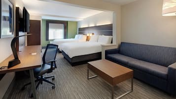 Une chambre d’hôtel comprenant un lit, un bureau avec une chaise, un canapé et un téléviseur.