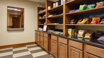 A kitchenette with wooden cabinets and a checkered floor.