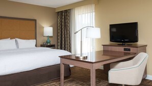A hotel room with a large bed, a desk with a chair, a television, and a lamp. - Hampton Inn & Suites Fremont (Fremont)