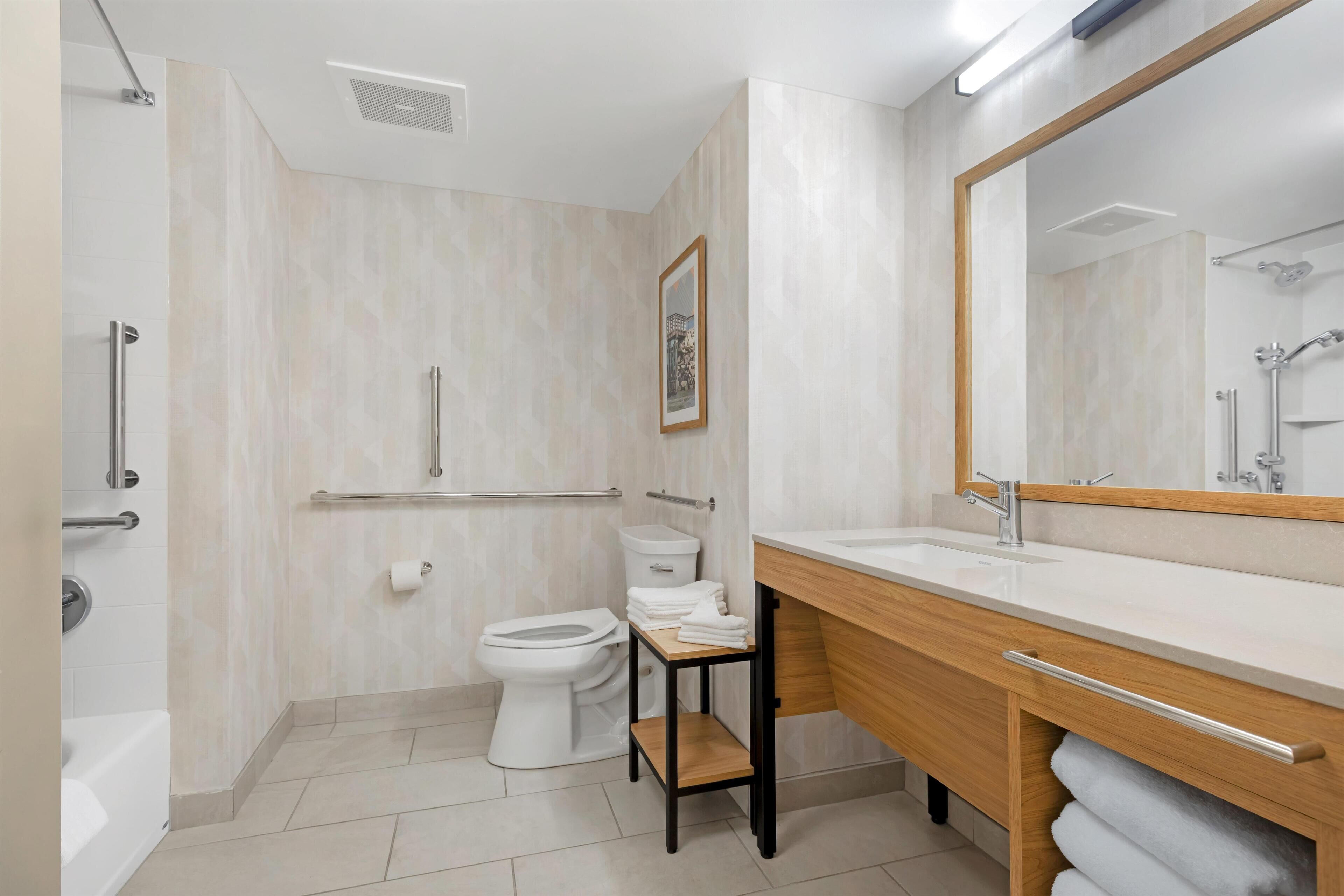 Un baño moderno con bañera, inodoro y tocador.