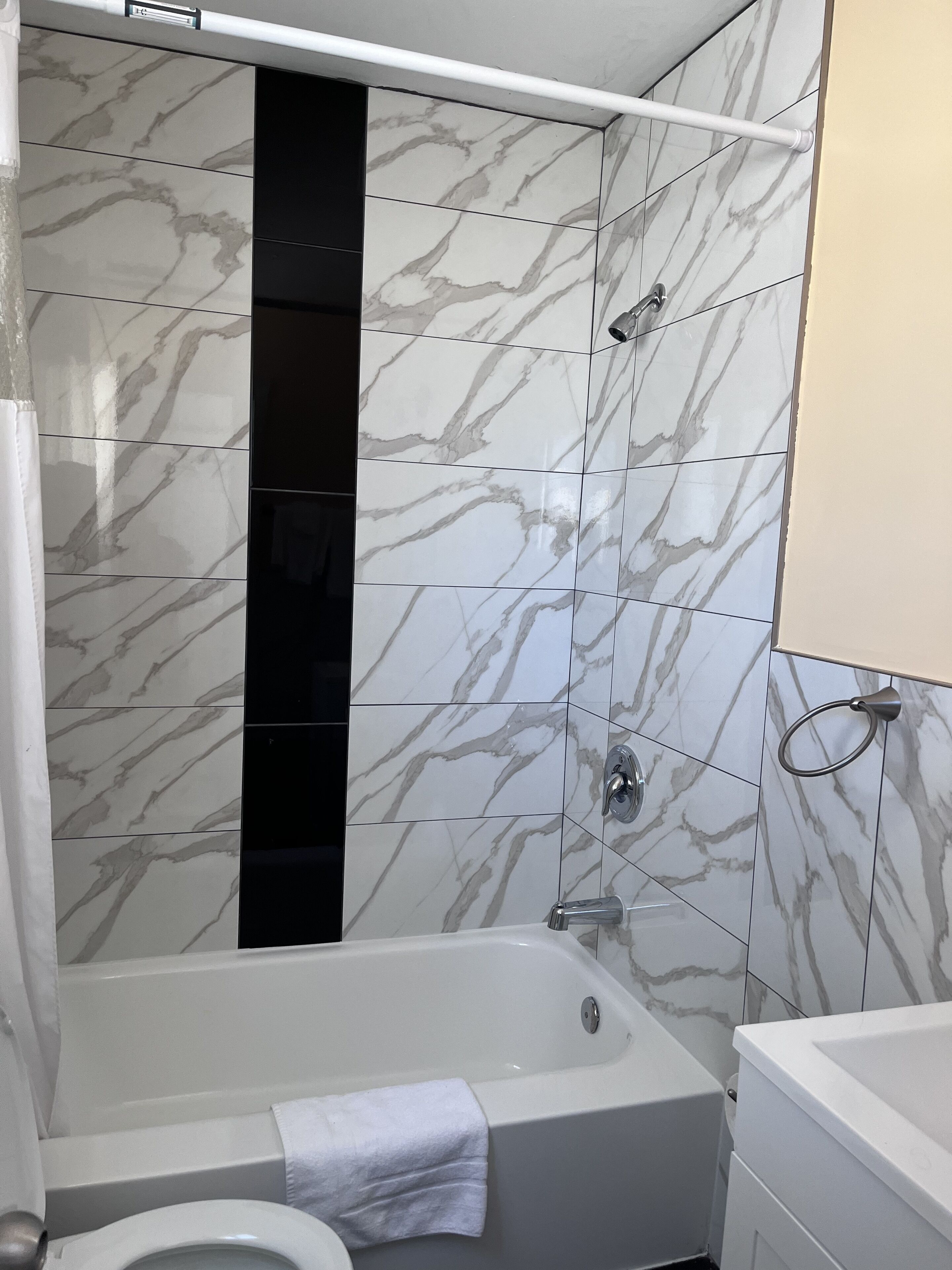 A bathroom with a bathtub, toilet, and a shower area.