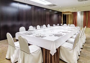 A conference room with a long table set for a meeting, surrounded by chairs. - Sercotel Puerta de la Catedral (Salamanca)