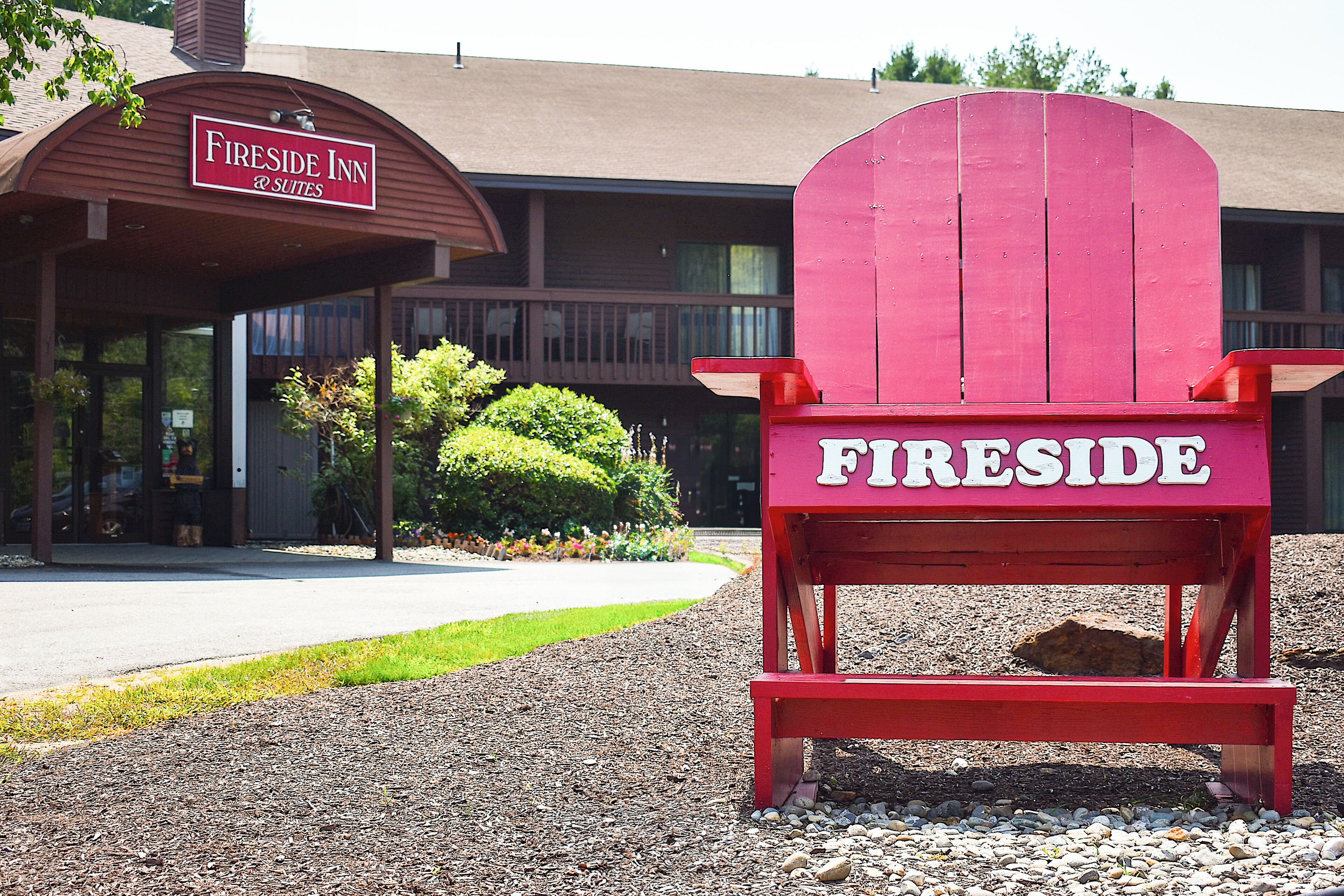 Punainen Adirondack-tyylinen tuoli, jonka selkämyksessä on sana ”Fireside”, on sijoitettu rakennuksen eteen. Rakennuksen kyltissä lukee: ”Fireside Inn & Suites”.