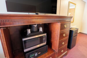 Un mini bar con microondas, cafetera y refrigerador.