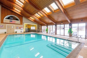 Una piscina cubierta, una piscina al aire libre de temporada, sombrillas