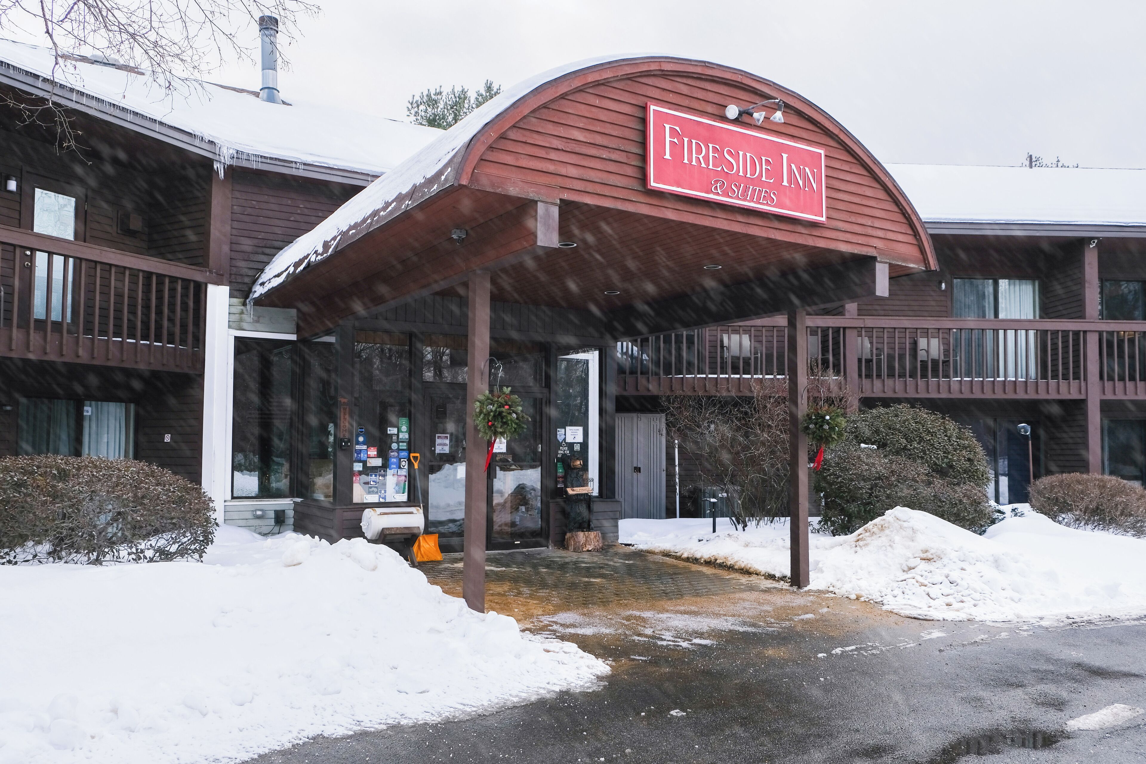 A Fireside Inn with a covered entrance, snow accumulation, and a sign indicating it offers suites.