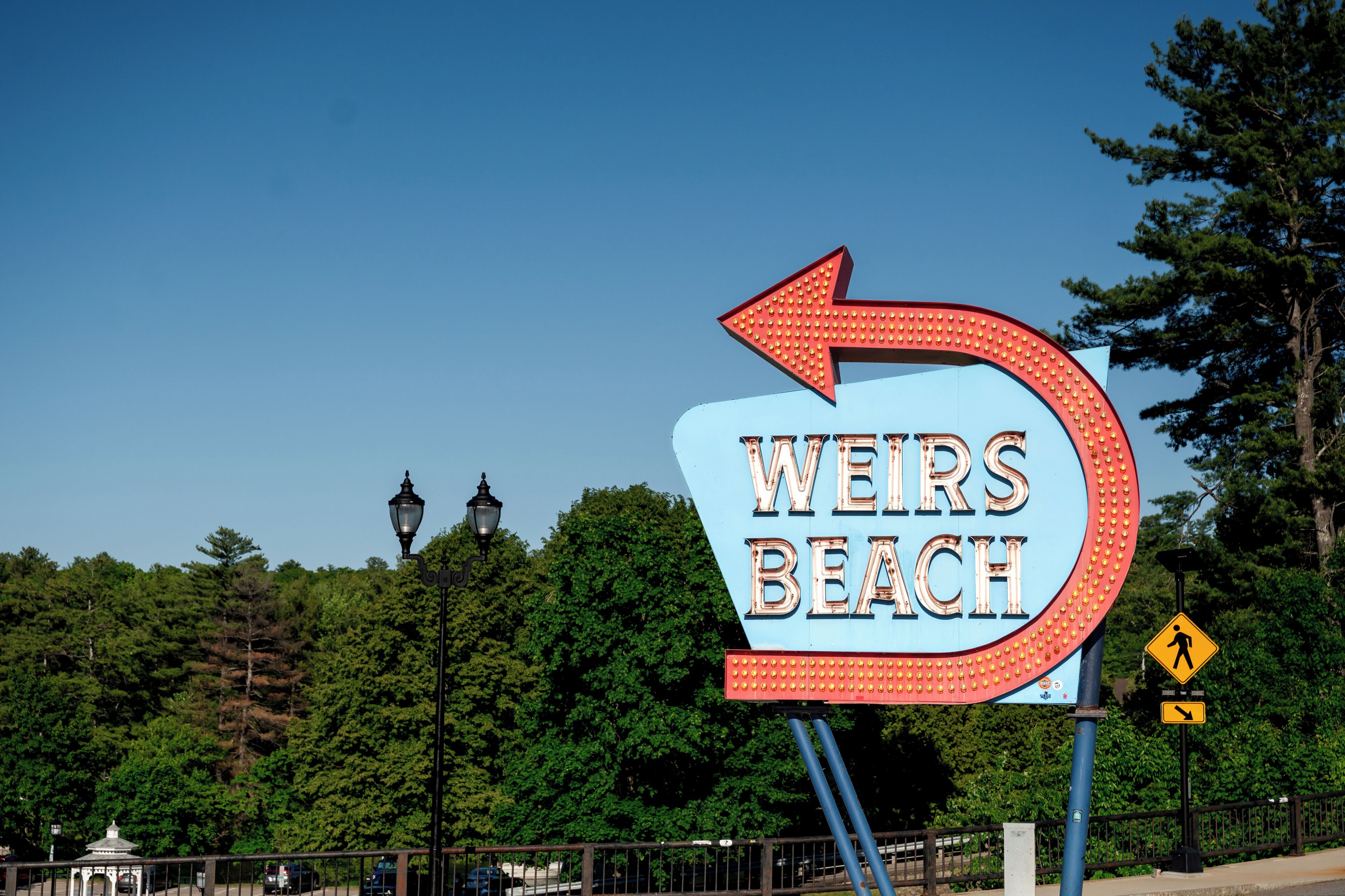 Señal direccional para 'Weirs Beach' con una flecha apuntando a la derecha.
