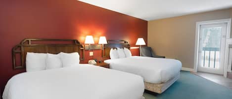 Habitación de hotel con dos camas, cabecero de madera, lámparas de noche, teléfono y vista al exterior a través de una puerta.