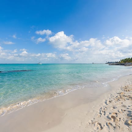 On the beach, white sand, sun loungers, beach umbrellas