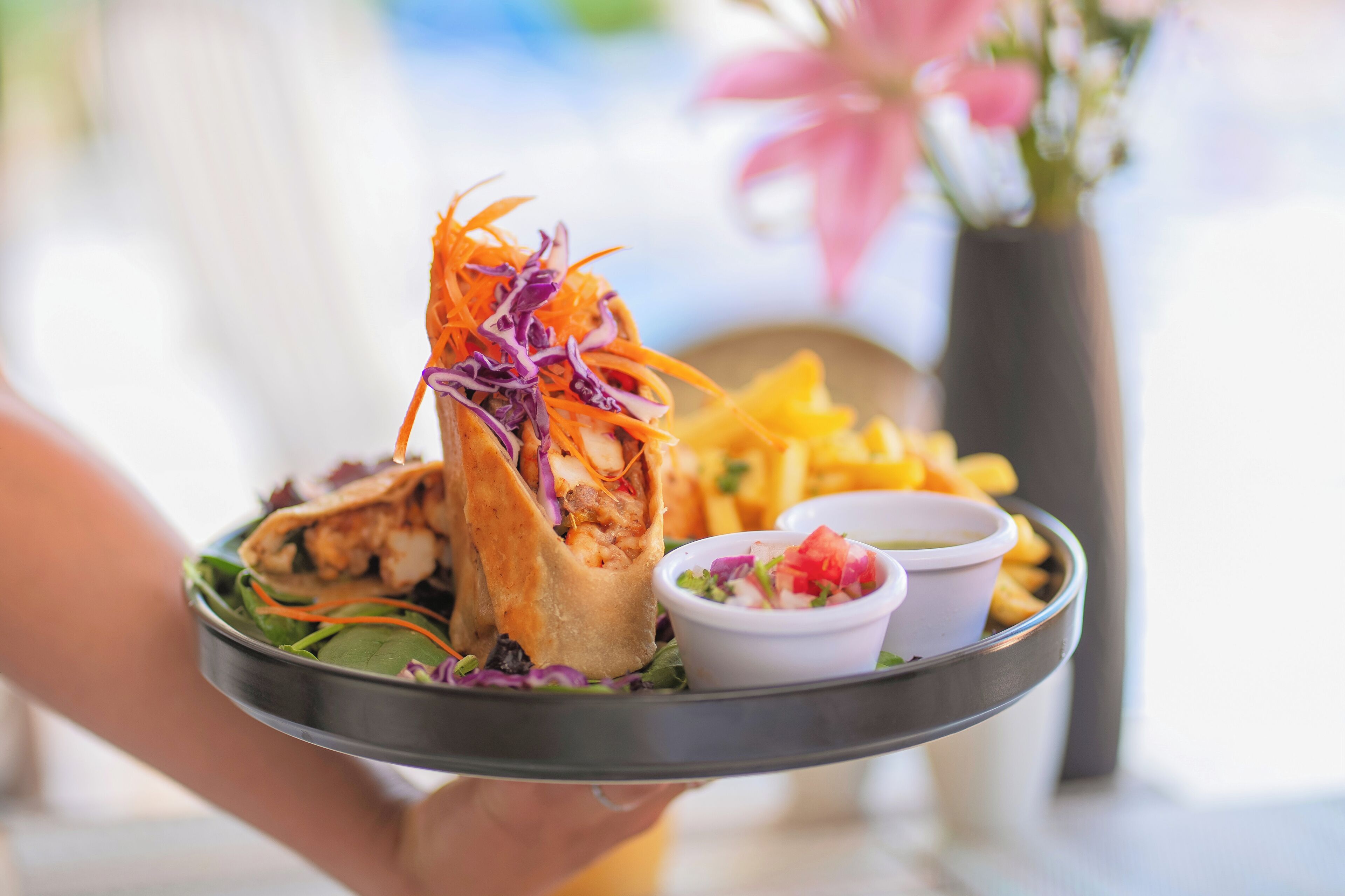 A tray with a wrap, fries, and a small salad.