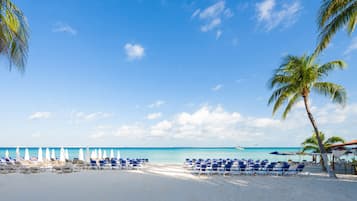 On the beach, white sand, sun loungers, beach umbrellas
