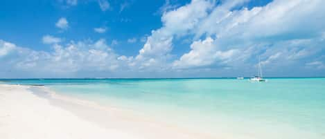 On the beach, white sand, sun loungers, beach umbrellas