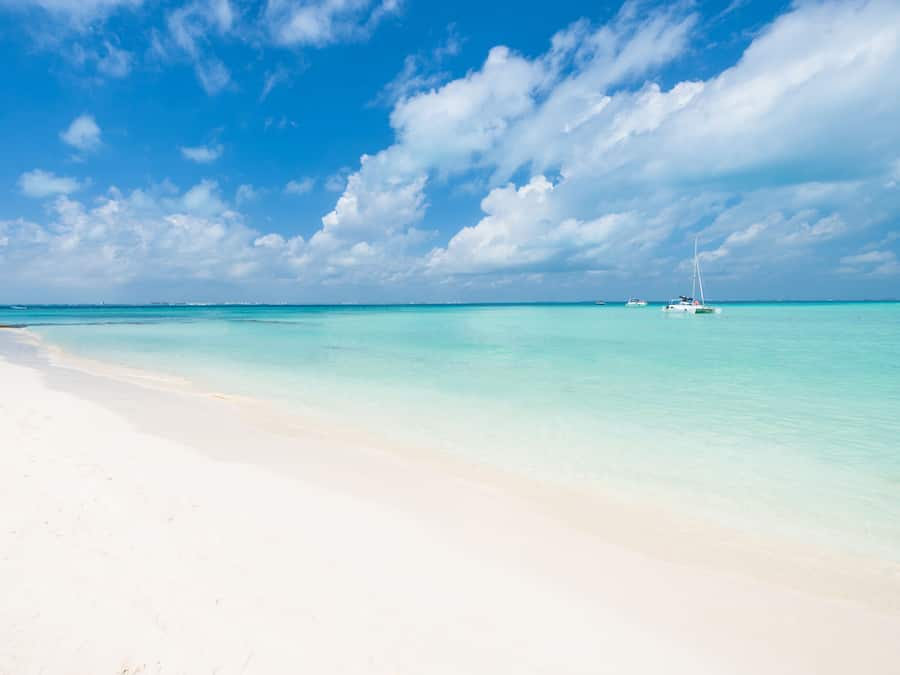 Aan het strand, wit zand, ligstoelen aan het strand, parasols