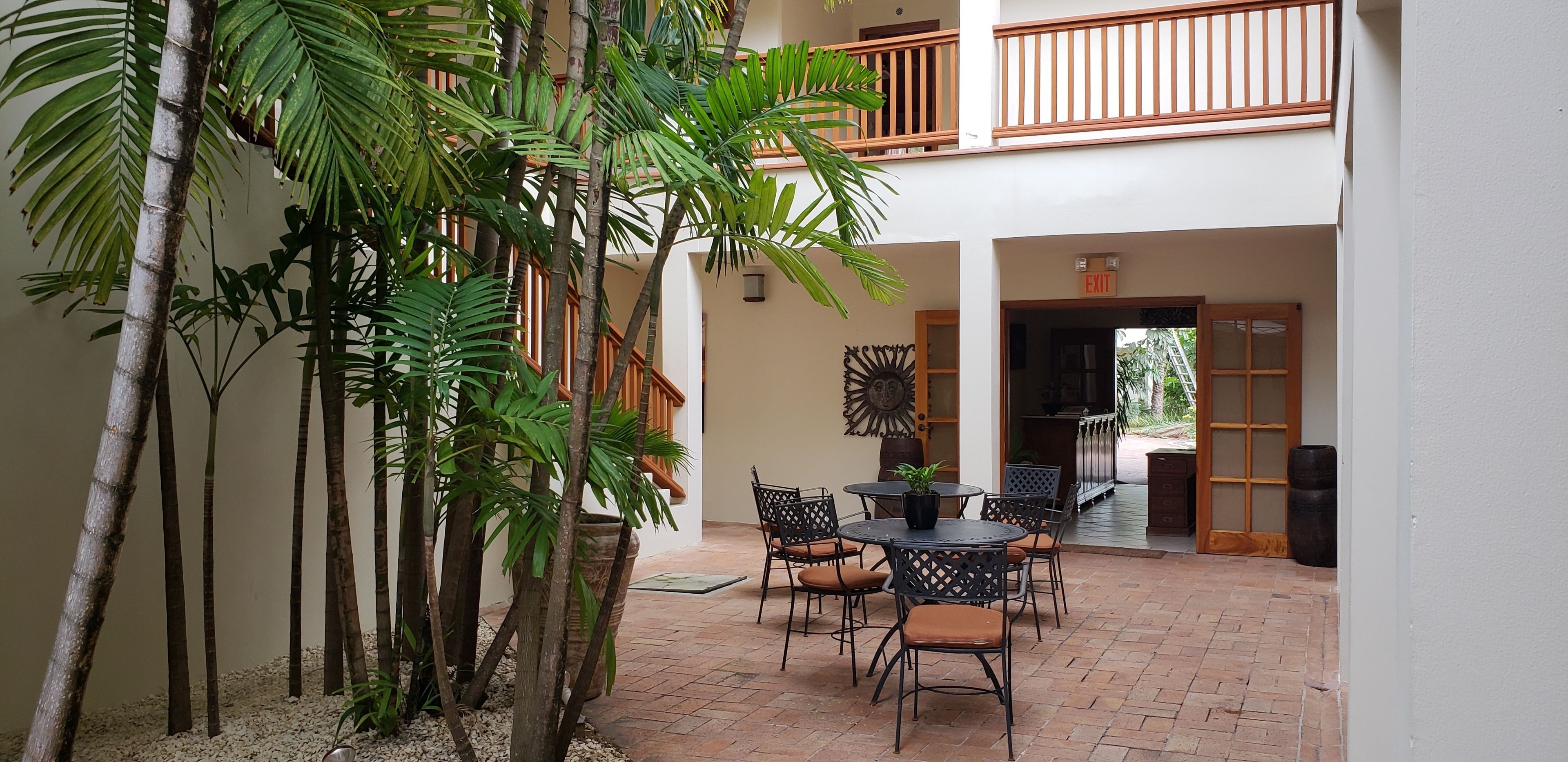A courtyard with a dining area, a staircase, and a view of the outside.