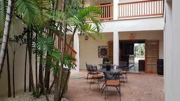 A courtyard with a dining area, a staircase, and a view of the outside.
